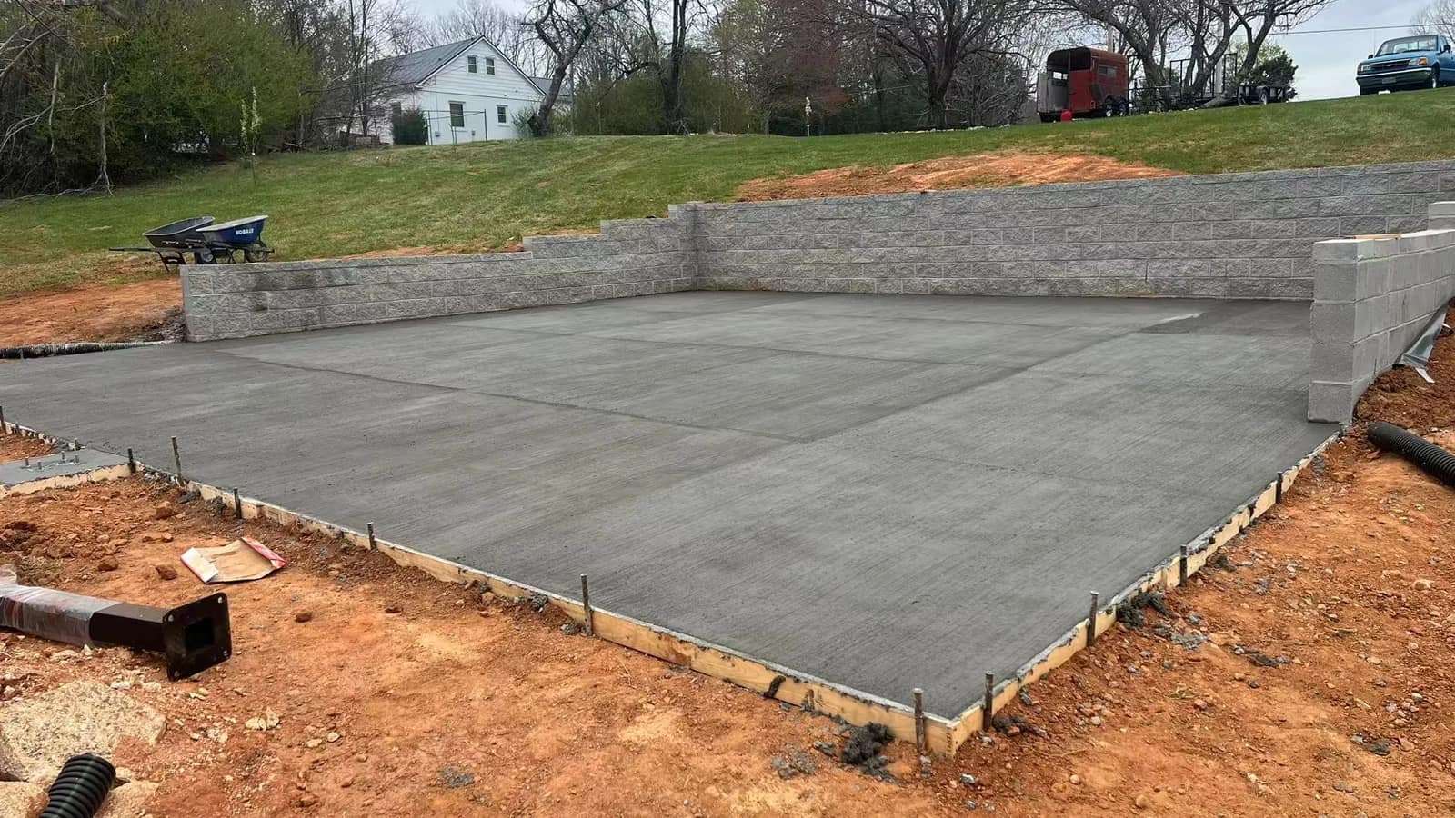 Newly placed concrete court base with retaining walls at an authorized customer project before modular tile installation.